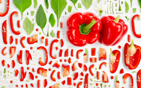 Abstrakter Hintergrund Aus Paprika Gemüsestücken Scheiben Und Blättern Auf Holzgrund — Stockfoto
