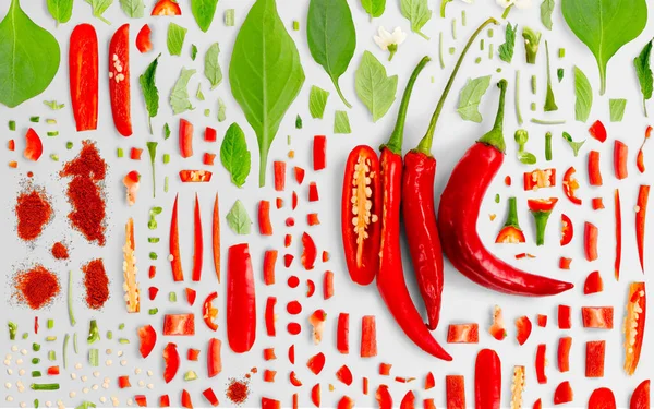 Abstraktní Pozadí Červené Chilli Papričky Kousky Zeleniny Plátky Listy Izolované — Stock fotografie