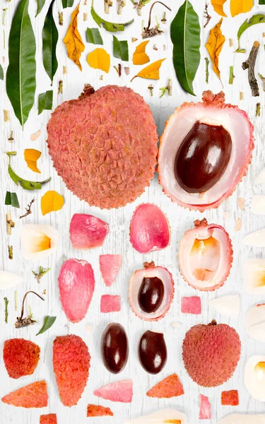 Abstrakter Hintergrund Aus Litchi Fruchtstücken Scheiben Und Blättern Auf Holzgrund — Stockfoto