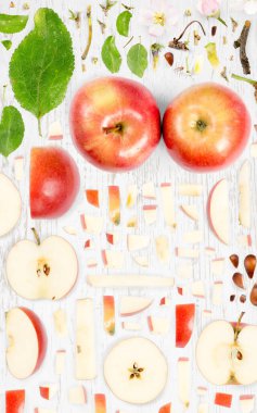 Tahta arka planda Red Apple meyve parçaları, dilimler ve yapraklardan oluşan soyut bir arkaplan.