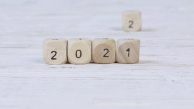 2021 numaralı tahta küpler 2022 'ye geçiyor. Yeni yıl ve zaman kavramı. Yüksek kalite durdurma hareketi 4k video.