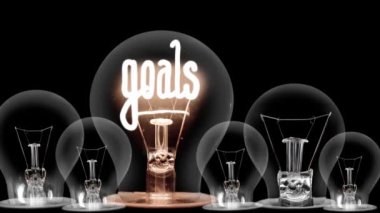 Siyah arkaplanda Smart Goals fiber metni olan ampuller karanlıktan aydınlığa gidiyor. Yüksek kalite 4k video