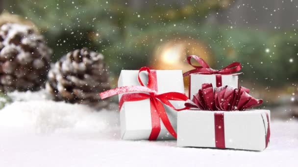 雪で覆われている贈り物グループとの生活 パインコーンはバックグラウンドで枝と黄金の装飾を紡ぎます 降雪効果について クリスマス 冬のコンセプト 高品質の4Kビデオ — ストック動画