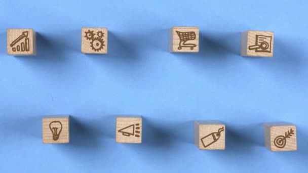 ターゲット ショッピングカート ライトバルブ グラフアイコンが中心に移動する木製ブロック マーケティングと戦略の概念 シームレスループ ブルーの背景 高品質の4Kビデオ — ストック動画