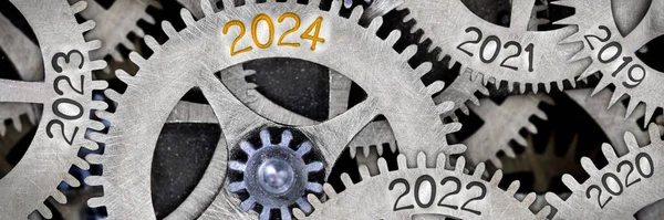 图为编号2024 2023 2022的齿轮机构印在金属表面的照片 新年概念 免版税图库照片