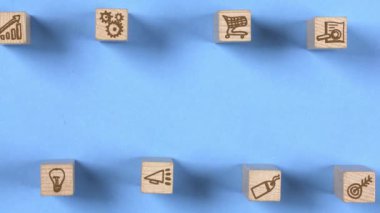 Reklamcılık, Hedef, Alışveriş Arabası, Ampul ve Grafik simgelerinin ortaya çıktığı tahta bloklar. Pazarlama ve Strateji kavramı. Mavi arka plan. Yüksek kalite 4k video.