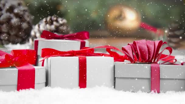 静谧的生活 礼物排在雪地覆盖的表面 松果和云杉分枝在后面 降雪的效果 圣诞节 假日和冬季的概念 优质4K视频 — 图库视频影像