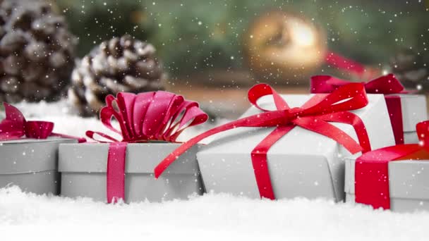 静谧的生活 礼物排在雪地覆盖的表面 松果和云杉分枝在后面 降雪的效果 圣诞节 假日和冬季的概念 优质4K视频 — 图库视频影像