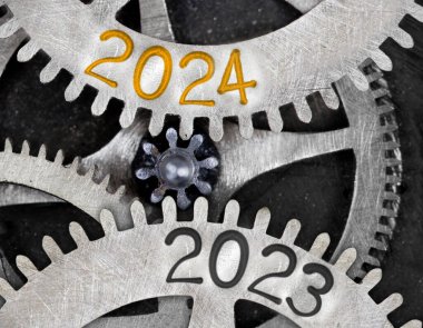 Metal yüzeyine 2024 ve 2023 numaralı diş çarkı mekanizmasının fotoğrafı basılmış. Yeni yıl konsepti.