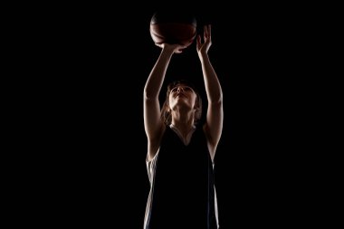 Kadın basketbol oyuncusu. Topu tutan güzel kız. Siyah arka planda yarım siluet stüdyo portresi..