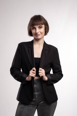 Kısa saçlı, iş kıyafeti giyen güzel bir kızın stüdyo portresi..