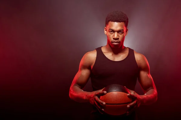 バスケットボールの選手側は ぼんやりとした背景にボールを保持赤い色で点灯 深刻な集中アフリカ系アメリカ人男性 — ストック写真