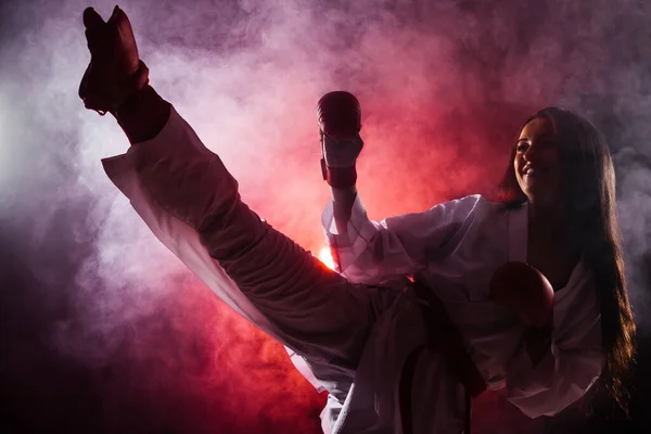 Chica Ejercicio Karate Pierna Kick Contra Rojo Niebla Fondo —  Fotos de Stock