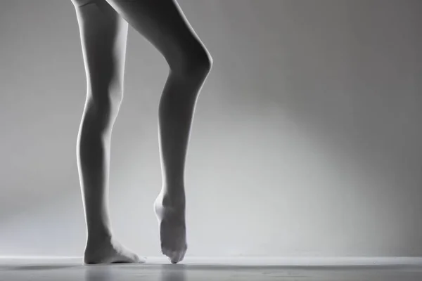 Σέξι Γυναικεία Πόδια Λευκά Κολάν Στέκεται Μπαλαρίνα Θέτουν Γκρι Φόντο — Φωτογραφία Αρχείου