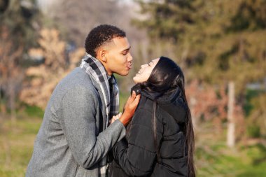 Parkta poz veren kadın ve erkek. Birbirine aşık çok ırklı bir çift..