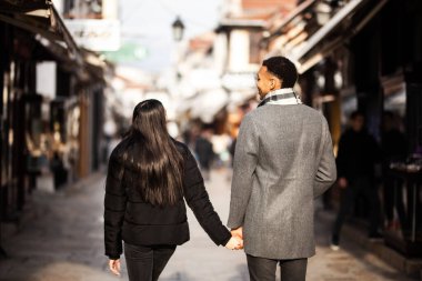 Dar sokaklarda poz veren çok ırklı bir çift. Üsküp, Kuzey Makedonya 'daki eski Türk Çarşısı.