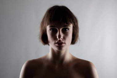 Kısa saçlı güzel esmer bir kızın yarım siluet portresi.