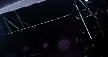 Müzikal performans sırasında sahne ışıklarının yanıp sönen ve dönen ışık huzmeleri