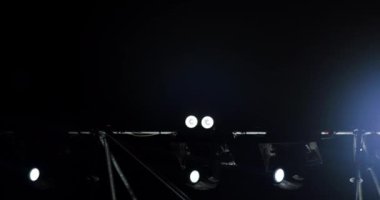 Müzikal performans sırasında sahne ışıklarının yanıp sönen ve dönen ışık huzmeleri