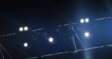 Müzikal performans sırasında sahne ışıklarının yanıp sönen ve dönen ışık huzmeleri