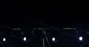 Müzikal performans sırasında sahne ışıklarının yanıp sönen ve dönen ışık huzmeleri