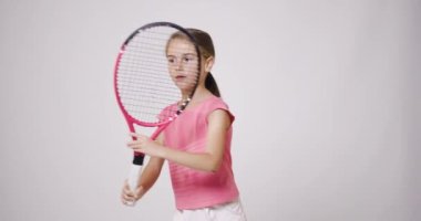 Genç bayan tenis oyuncusu. Pembe spor kıyafetli kız forehand hareketi çalışıyor..