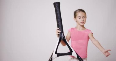 Büyük raket fırlatma topuyla genç bayan tenisçi. Pembe spor kıyafetli kız..