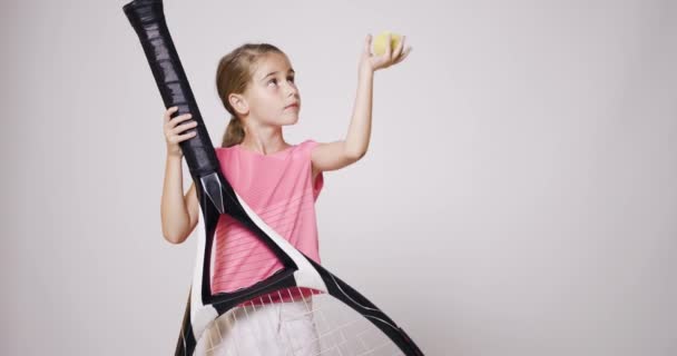 大きなオーバーサイズのラケットを持つ若い女性テニス選手 ピンクのスポーツ服を着て 彼女の手でボールを跳ねる女の子 — ストック動画