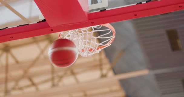 バスケットボールはガラスの板の上のフープに向かって飛んでいる ボールを投げ ネットを押してリングを逃す 下からの眺め — ストック動画