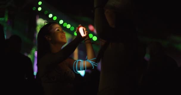 二人の若い女の子がステージの前で群衆の中で踊る 低光ビデオ 120Fpsのスローモーションレコーダー — ストック動画