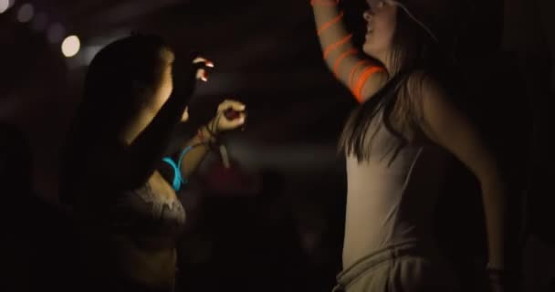二人の若い女の子が舞台の前で踊って飛び跳ねる 背景にいる人たちの集中力のなさから — ストック動画