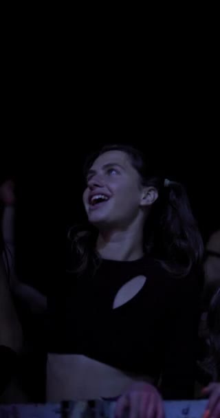 点滅するライトでステージの前で群衆の中に踊る女の子 垂直ビデオ — ストック動画