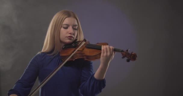 Schöne Blonde Frau Spielt Geige Vor Blauem Und Violettem Rauch — Stockvideo