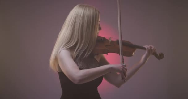 Beautiful Blond Woman Playing Violin Pink Spotlight Smoke Background — Video