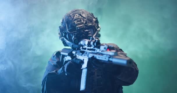 背景には青と緑の煙で敵にライフルを狙う戦術装備と保護を完備した兵士 — ストック動画
