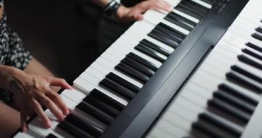 Klavye çalan bir kız. DJ ya da müzik yapımcısı stüdyoda ses kaydı yapıyor. Yukarıdan görüntüle.