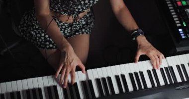 Klavye çalan bir kız. DJ ya da müzik yapımcısı stüdyoda ses kaydı yapıyor. Yukarıdan görüntüle.