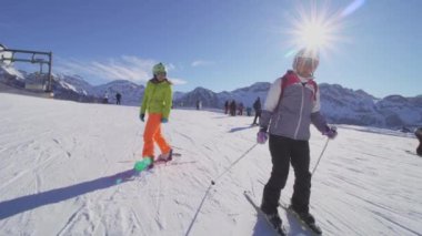 Kayak ve snowboard yapan kızlar bayırlarda kayak yapmaya hazırlanıyorlar.-