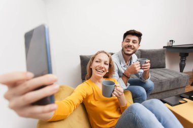 Birbirini seven çiftler selfie çekiyor, gülümsüyor ve evde eğleniyorlar.