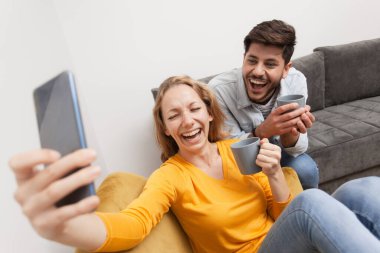 couple in love taking selfie and having fun at home. both smiling