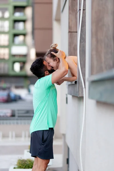 恋爱中的情侣男孩站在室外从窗户里吻一个女孩 — 图库照片