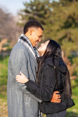 Parkta poz veren kadın ve erkek. Birbirine aşık çok ırklı bir çift..