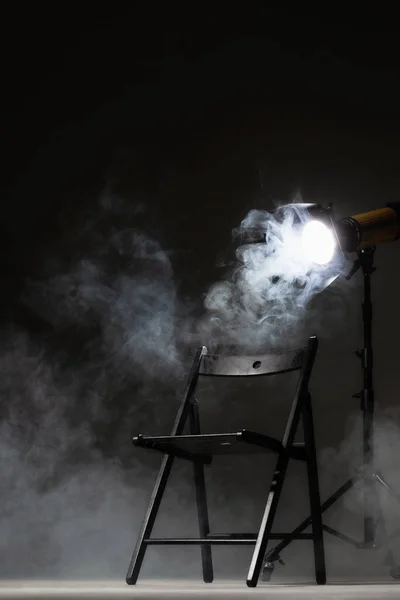 スタンドにライトを当て 映画監督たちが椅子に座る 背景に煙 — ストック写真