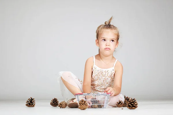 Kleines Kaukasisches Mädchen Spielt Mit Tannenzapfen — Stockfoto
