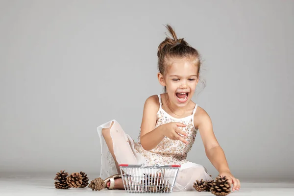 Pequena Menina Caucasiana Brincando Com Pinhas — Fotografia de Stock
