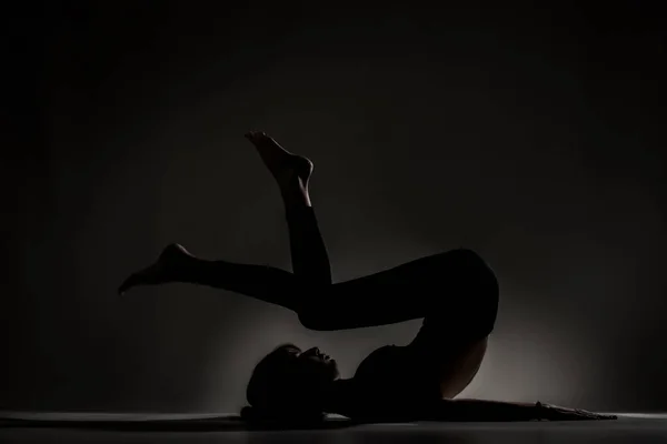 Zdolna Baletnica Kłamie Rozciąga Się Ćwicząc Jogę Sylwetka Oświetlona Bocznie — Zdjęcie stockowe