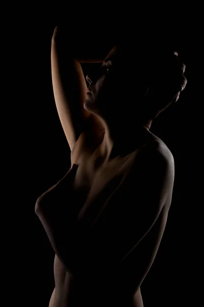 暗い背景に短い髪の少女の肖像画 女性の体の側面照明付き輪郭シルエット — ストック写真