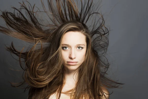 Brunetka Dívka Tekoucími Vlasy Vzduchu Studio Portrét Proti Šedému Pozadí — Stock fotografie
