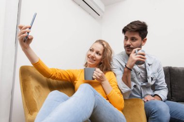 Birbirini seven çiftler selfie çekiyor, gülümsüyor ve evde eğleniyorlar.