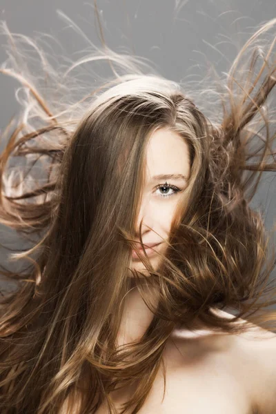 Havada Dalgalı Saçları Olan Esmer Kız Stüdyoda Gri Arka Planda — Stok fotoğraf